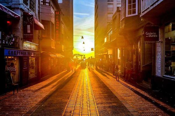 A couple walking hand-in-hand on a beach at sunset.